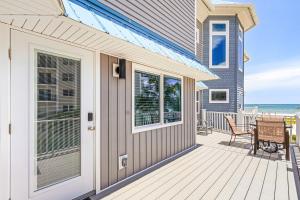 a house with a deck with a table and chairs at -Warm Sands- Fantastic Gulf Front Duplex! home in Fort Myers Beach