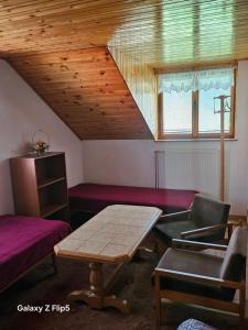 a room with a table and a couch and a window at Privát Marika in Terchová