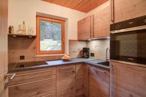 a kitchen with wooden cabinets and a window at Ferienwohnungen Kimpfbeck, Kreuth-Schärfen in Kreuth