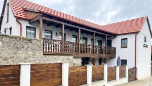 a house with a wooden deck and a fence at Lator-Hans Apartmanház in Villány