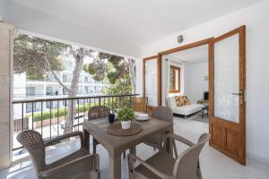 a dining room with a table and chairs on a balcony at Apartamentos MHM in Cala Ratjada