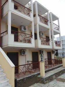 a white building with red balconies and stairs at Hotel Kosmas in Sarti