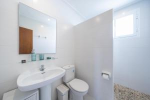 a white bathroom with a sink and a toilet at Apartamentos MHM in Cala Ratjada +113 photos