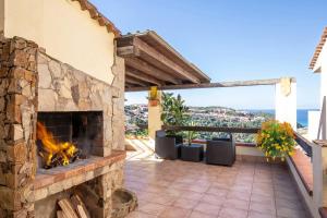 a fireplace on a patio with a view of the ocean at Costa Verde - Panoramic Stay Terrace Wifi BBQ AC in Torre Dei Corsari +12 photos