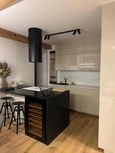 a kitchen with a black island with a counter top at Apartmán Máj 104 in Pec pod Sněžkou