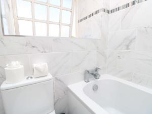 ein weißes Badezimmer mit Toilette und Waschbecken in der Unterkunft Stable Cottage in Ventnor + 34 Fotos