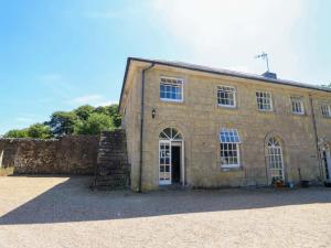 ein großes Steingebäude mit einer Tür und Fenstern in der Unterkunft Stable Cottage in Ventnor