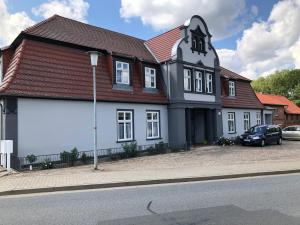 a large white house with a red roof at Gemütliche Wohnung im Gutshaus in Lalendorf