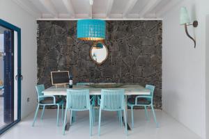 a dining room with a table and blue chairs at Villa Lunamoon, Playa Blanca in Playa Blanca