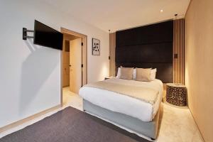 une chambre avec un grand lit et une télévision à écran plat dans l'établissement Sleeper Cottage - Sleeps 8, à Scarborough