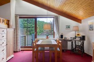 ein Esszimmer mit einem Tisch und einem großen Fenster in der Unterkunft Gästehaus Himmelswiese Ingo Reetz in Schönwald