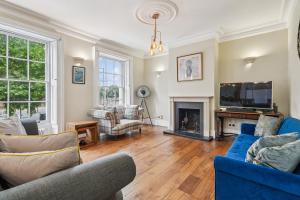 a living room with blue furniture and a fireplace at Finest Retreats - Palace Gate, Hampton Court in East Molesey