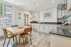 a large kitchen with a wooden table and chairs at Finest Retreats - Palace Gate, Hampton Court in East Molesey