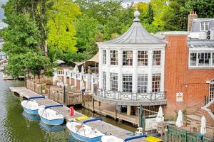 a group of boats docked at a building on a river at Finest Retreats - Palace Gate, Hampton Court in East Molesey