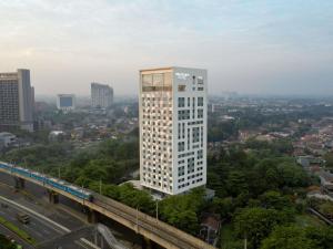 Un alto edificio bianco nel mezzo di una città di Mercure Jakarta Simatupang a Giacarta