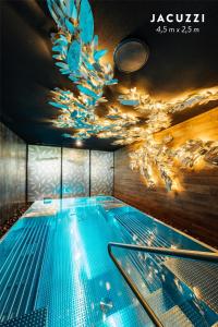 a swimming pool with a chandelier in a room at Radisson Blu Carlton Hotel, Bratislava in Bratislava