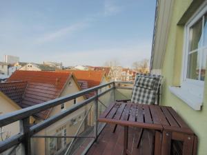 a wooden chair sitting on a balcony with a view at Möwenblick Fewo Ramm in Warnemünde