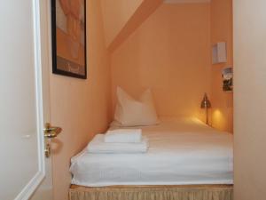 a bed with white sheets and pillows in a room at Möwenblick Fewo Ramm in Warnemünde