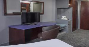 a room with a desk with a tv and a chair at Sheffield Metropolitan Hotel by Belvilla in Sheffield +111 photos