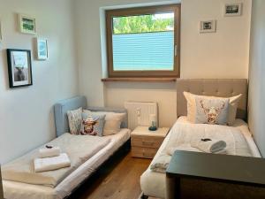 dwa łóżka w pokoju z oknem w obiekcie Appartement Lana - by NV-Appartements w mieście Kirchberg in Tirol