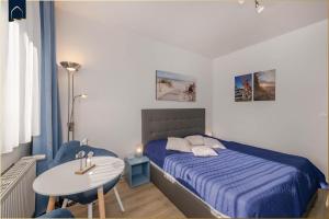a small bedroom with a bed and a table at Nur 100m zum Strand FeWo Seebrise 109 by Pro Home Appartements in Zempin