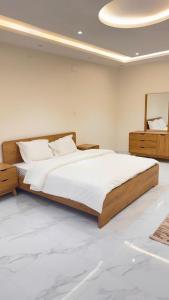 Un dormitorio con una cama grande y un espejo. en شقق الربيع, en Al Bahah