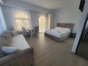a bedroom with a bed and a couch and a table at Juli's apartment in Livadhja