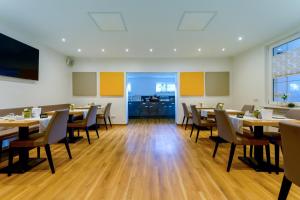 una sala da pranzo con tavoli e sedie in legno di Landgasthof Ritter a Orsingen-Nenzingen