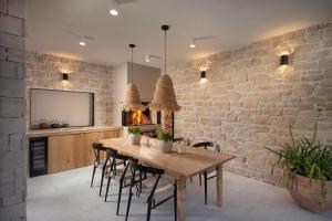 a dining room with a wooden table and a brick wall at Villa Novita in Pazin