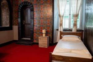 a bedroom with a bed and a window and a door at The Englishman's Clock Tower Hostel & More in Shkodër +39 photos