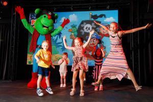 a group of children dancing on a stage with mascots at VIVA Sunrise in Port d'Alcudia