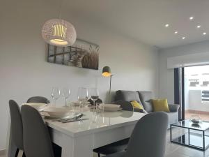 una sala da pranzo bianca con tavolo e sedie di Apartamento acogedor con piscina común en San Juan de los Terreros, cerca de la playa - ES-376-13 a Pulpí