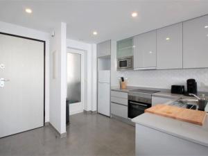 una cucina con mobili bianchi e un lavandino di Apartamento encantador con piscina comunitaria en San Juan de los Terreros - ES-376-17 a Pulpí