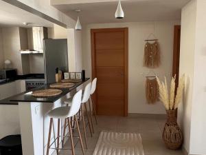 una cucina con bancone e sgabelli di Apartamento en Andalucía para 4 pers. con piscina y WiFi, cerca de la playa - ES-376-37 a Pulpí