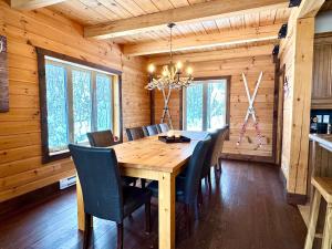 a dining room with a wooden table and chairs at Ski Chalet - Mountain and Spa - Chalet Heritage in Saint-Philémon +26 photos