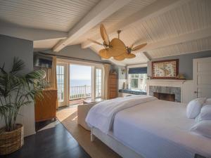 Un dormitorio con una cama y un ventilador de techo. en Santa Barbara Beach Club, en Santa Bárbara 36 fotos más