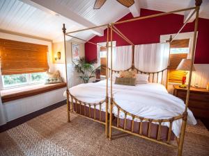 1 dormitorio con cama con dosel y pared roja en Santa Barbara Beach Club, en Santa Bárbara