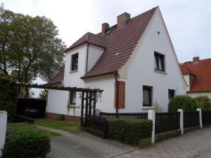 a white house with a brown roof and a fence at Apartment in Bergen auf Rügen 2835 in Bergen auf Rügen