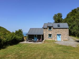 a stone house with a slate roof on a hill at Dolwylan Barn in Llandysul
