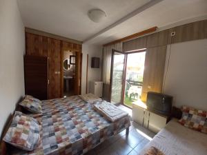 Un dormitorio con una cama y un televisor. en Amelia Accommodation Pestani Ohrid, en Ohrid