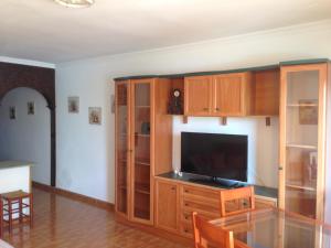 a living room with a television and wooden cabinets at Apartamento Muelle de Corralejo 14 in Corralejo