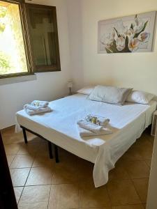 a large bed with two towels on top of it at VILLA MÀRCATO tra Monti & Mare in San Vito lo Capo