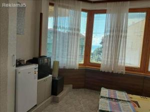 a room with a refrigerator and a tv and windows at Amelia Accommodation Pestani Ohrid in Ohrid