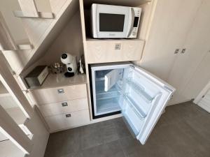 a small kitchen with a refrigerator with a microwave at Le Potager in Quartu SantʼElena