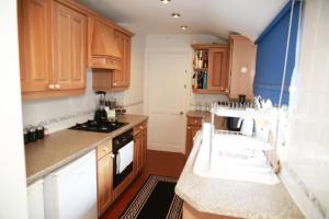 a kitchen with wooden cabinets and a stove top oven at Diamond in Abbey Wood