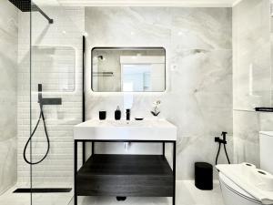 a white bathroom with a sink and a mirror at Almancil Typical House by Homing in Almancil +20 photos