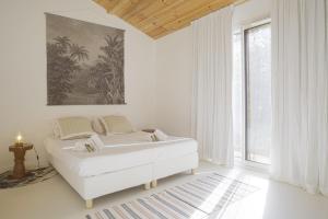 a white room with a bed and a large window at La Maison Boisée - Welkeys in Orx +22 photos