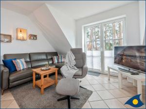 a living room with a couch and a tv at Fraeulein Loddin Whg_ Hugo in Kölpinsee +29 photos