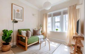a living room with a green couch and a window at BnBNova - 1BR - Holborn & Central London - The Museum in London