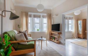 a living room with a green chair and a television at BnBNova - 1BR - Holborn & Central London - The Museum in London +14 photos